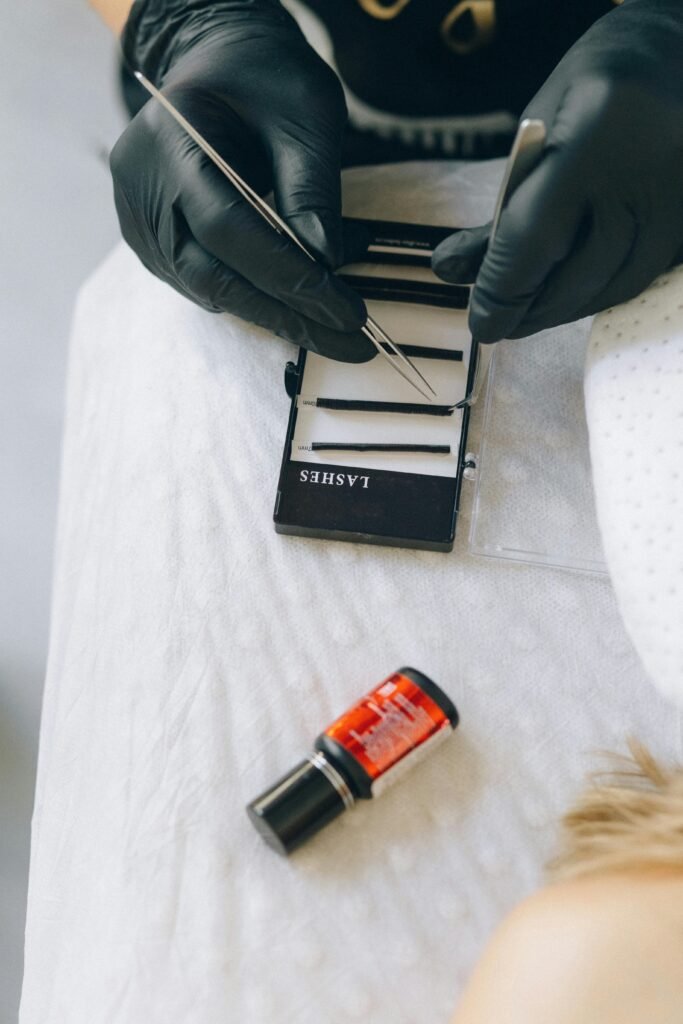 Close-up of a lash technician applying eyelash extensions in a beauty salon.